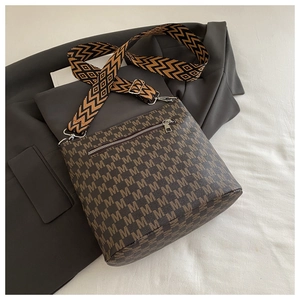 Detail of coffee shoulder bag with letter M pattern and wide geometric woven strap