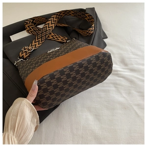 Detail of brown monogram jacquard crossbody bag with patterned wide fabric strap