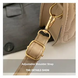 Detail of beige quilted leather bag with adjustable strap and golden metal hardware