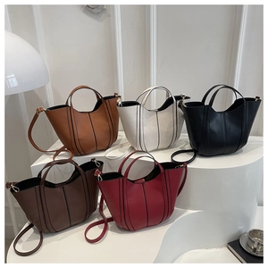 Five assorted colors of mini tote bags with vertical stitching on minimalist display