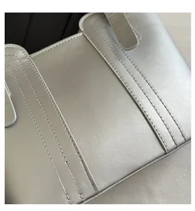 Detailed close-up of metallic silver leather texture with double-stitched sewing details