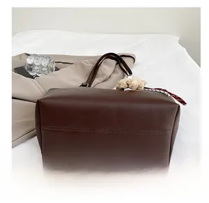 Détail du fond en cuir lisse du sac cabas marron foncé avec charm d'ours mignon