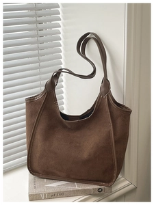 Detail of soft dark brown matte tote bag texture on a windowsill with warm lighting