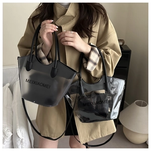 Détail du grand sac cabas en PVC gris avec lanières en cuir noir et logo MEIXIAOMEI