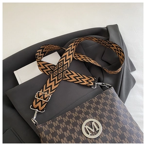 Macro detail of brown leather bag with M pattern and ethnic geometric wide shoulder strap
