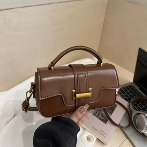 Retro brown polished leather small square handbag with gold buckle in lifestyle setting