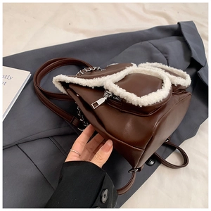 Close-up of brown mini backpack with white fleece trim and silver chain details