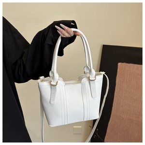 Detail of white PU leather tote bag with gold ring hardware and adjustable shoulder strap