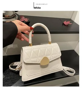Détail du sac à main carré blanc avec texture crocodile et fermoir magnétique doré