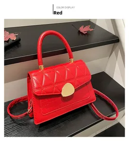 Détail du sac rouge en cuir PU avec rabat matelassé, motif crocodile et fermoir doré