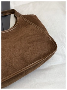 Detail view of large dark brown tote bag showing textured faux suede fabric and fine stitching
