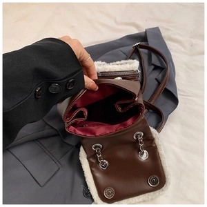 Detailed interior of a brown leather bag with white wool trim and a red fabric lining