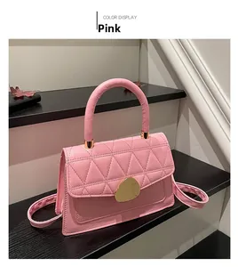 Détail du sac à main rose avec surpiqûres triangle, relief croco et boucle en métal doré