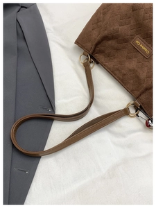 Detail of coffee brown suede tote bag featuring diamond quilt pattern and tag