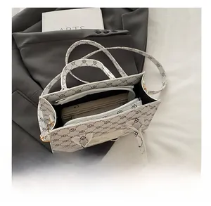Top view of white tote bag interior with storage capacity showing a phone and wallet