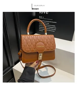 Detailed view of brown quilted tote bag with metal twist lock and fashion emblem