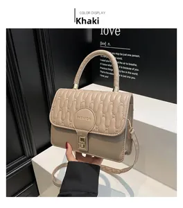 Detail of khaki crossbody bag featuring vertical quilting and golden fashion lock buckle