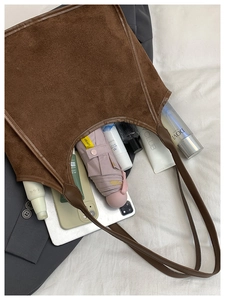 Top view of brown plush tote bag showing large capacity with daily essentials inside