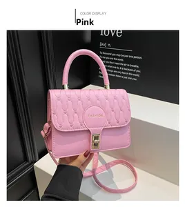Detail of pink quilted handbag featuring a golden turn-lock closure and FASHION lettering