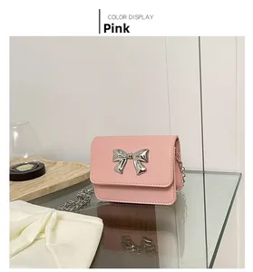 Detailed view of pink mini square bag with silver bow buckle and elegant metal chain strap
