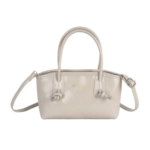 Stylish beige faux leather tote bag with knotted handles and gold lettering text