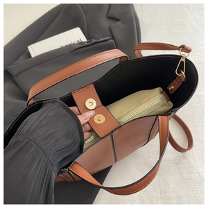 Brown tote bag interior showing beige canvas organizer insert and magnetic closure