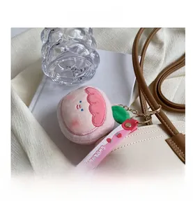 Pink plush peach bag charm with Sweet printed strap and metal clasp on detail display