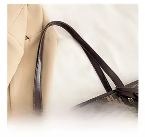 Detail of dark brown tote bag with Monogram M print and gold rivet reinforcement