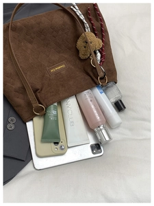 Brown corduroy tote bag detail showing large capacity with tablet and cosmetic items