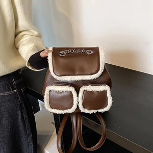 Fashionable dark brown leather backpack with white faux shearling trim and silver chain handle