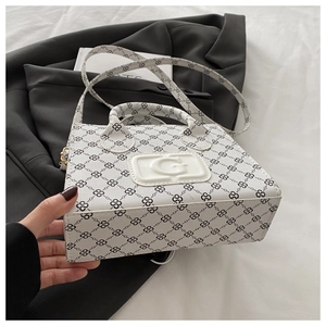 Detail view of white leather crossbody bag featuring G-embossing and chain patterns