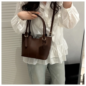 Deep brown matte faux leather tote bag with metal buckle detail and adjustable strap
