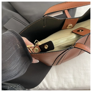 Detail view of leather tote interior with fabric liner bag and gold snap closure