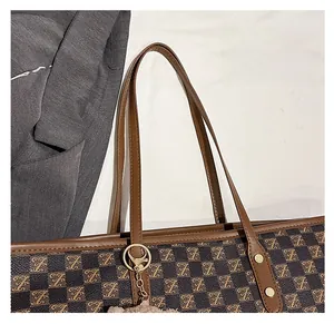Detail of soft brown leather shoulder strap and gold hardware on tote bag