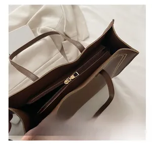 Détail de la fermeture éclair dorée et de la poche intérieure du sac en cuir marron