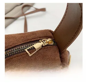 Macro detail of golden metal zipper and soft brown suede texture on a large tote bag