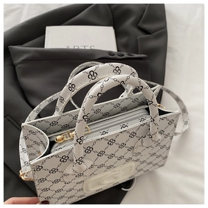 Detail of white PU leather crossbody bag with black chain print and golden metal zipper