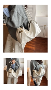 Macro detail of white leather hobo bag with side lettering and plush cat charm