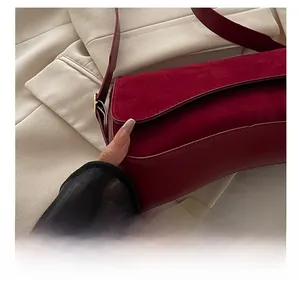 Close-up of wine red suede texture and precision stitching on vintage flap bag