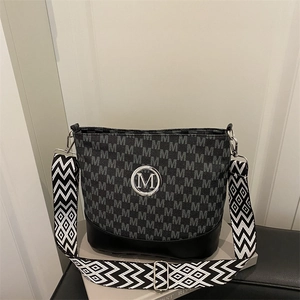 Chic bucket shoulder bag with letter print and wide geometric strap on display
