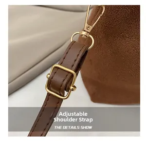 Detail of adjustable brown suede strap with elegant gold metal buckle and precision stitching