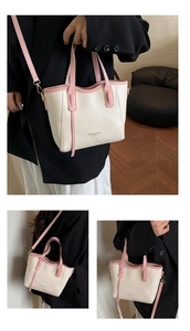 Detail view of pink and off-white contrast leather bucket bag with adjustable straps