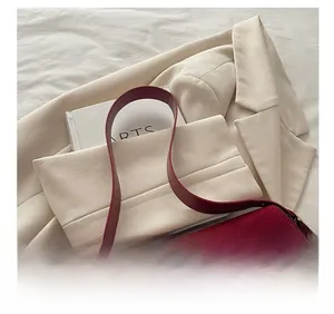 Close-up of deep red matte leather shoulder bag with smooth leather strap detail