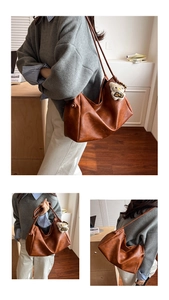 Macro shot of large brown tote bag showing leather texture and knot detail on the side