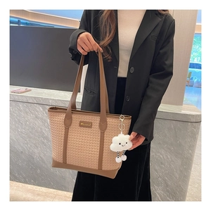 Détail du sac cabas tissé beige et marron avec logo doré et charm nuage en peluche