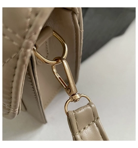 Détail du fermoir en métal doré et de l'anneau en D sur sac en cuir matelassé