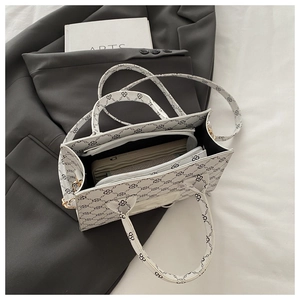 Detailed interior of white tote bag showing multiple compartments and zipper pockets