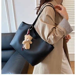 Détail du sac cabas noir en cuir PU avec lettrage doré et charmant pendentif d'ours
