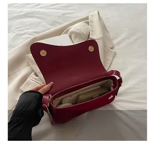 Detail view of the deep red shoulder bag showing spacious interior for phone and wallet
