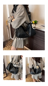 Detail of black pleated faux leather tote bag featuring a cute character bag charm